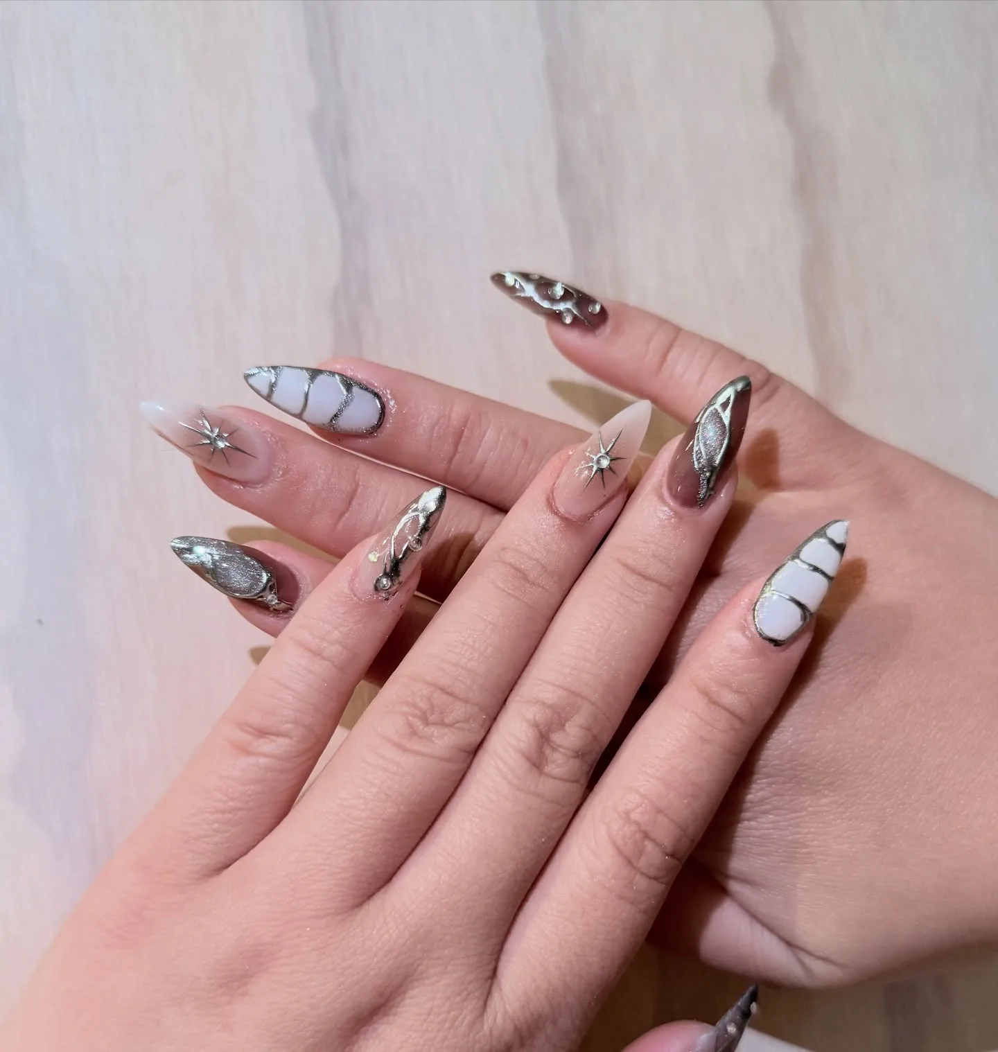 Chrome and marble almond nails with 3D silver starburst wire accents