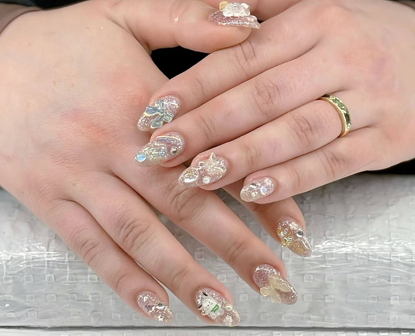 Iridescent rounded nails with 3D clear bows, flowers and rhinestones