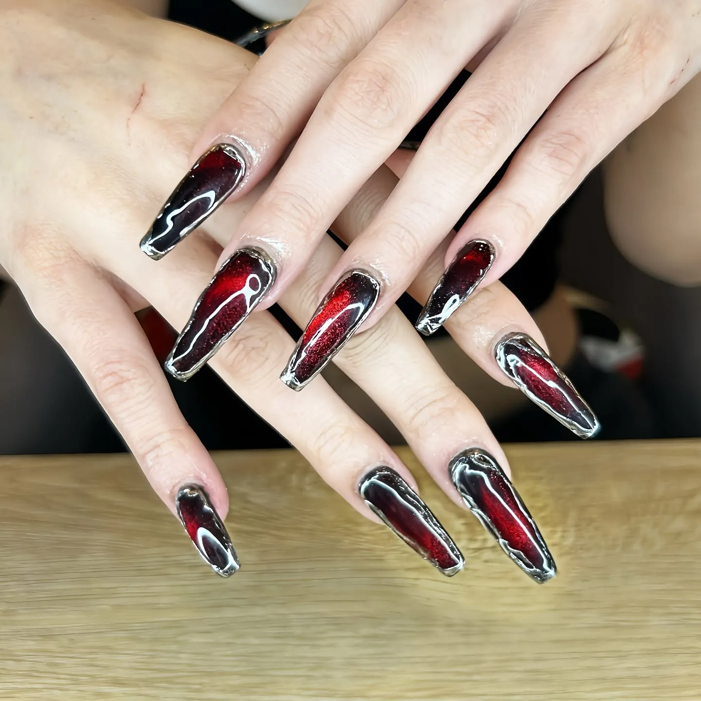 Dark red cat-eye chrome coffin nails with silver metallic borders