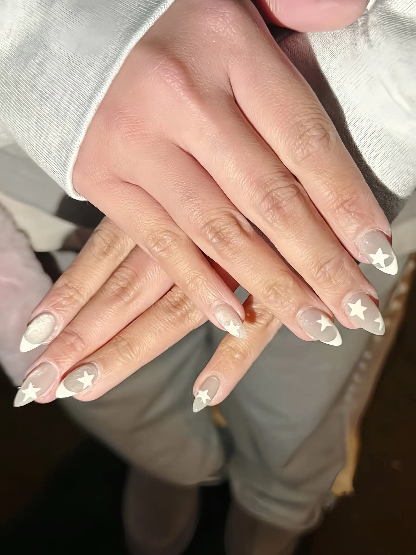 Sheer milky grey almond nails with white star and crescent accents