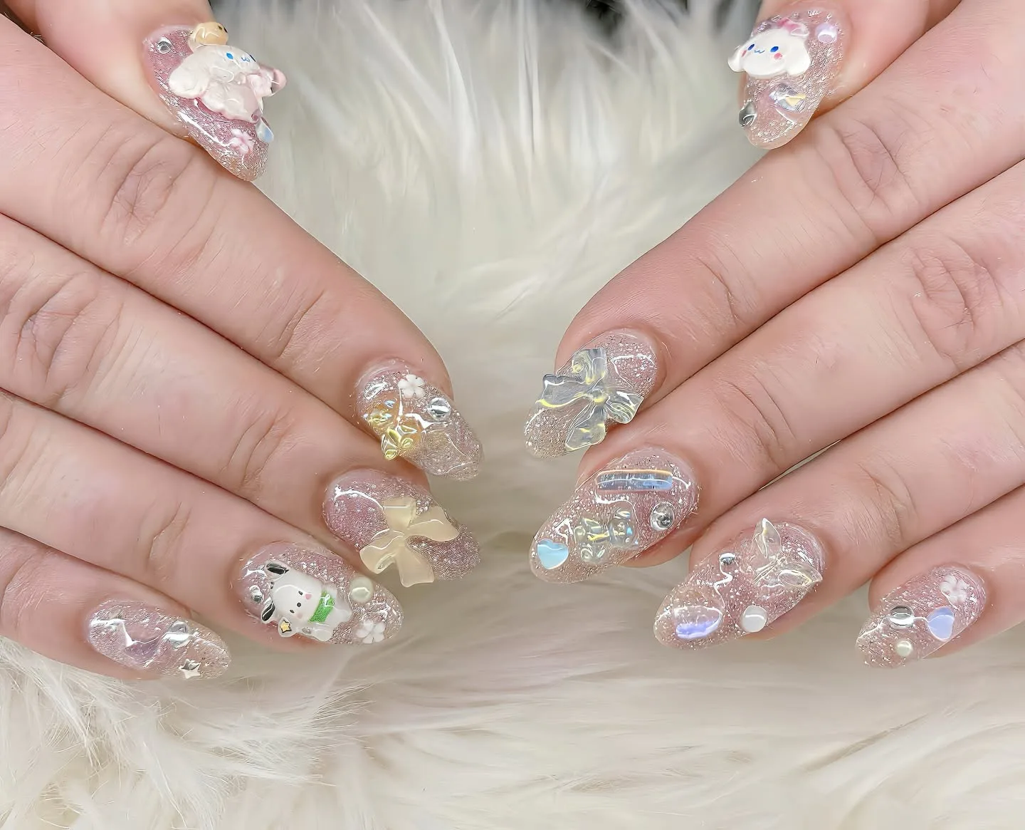 Clear rounded nails covered in 3D bows, flowers and rhinestones